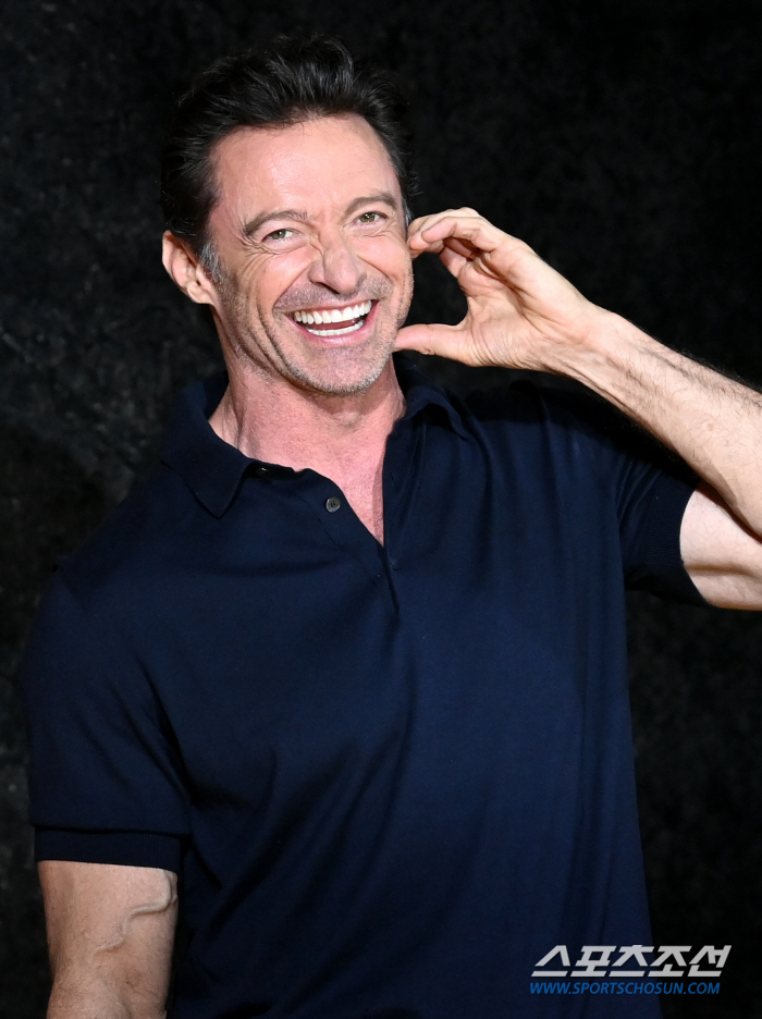  Hugh Jackman smiles as he shows a cheek heart