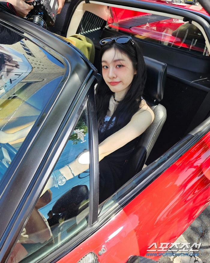  Kim Yu-na, frowned by the hot sun, grabs the wheel of an open car and 's smile'