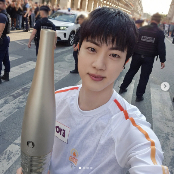 'Handsome' Jin took a selfie during the torch relay for the Paris Olympics