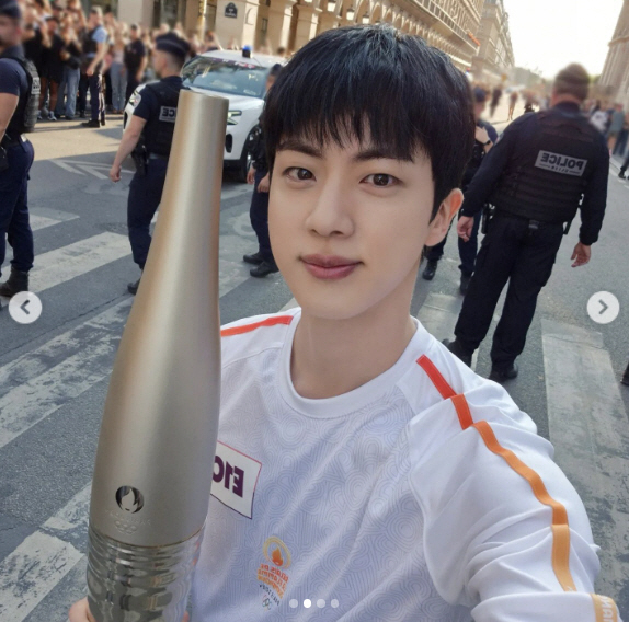 'Handsome' Jin took a selfie during the torch relay for the Paris Olympics