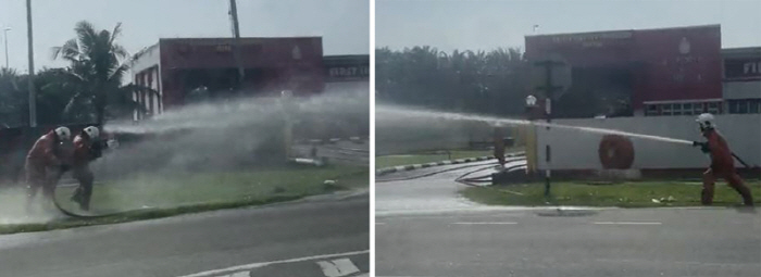 Firemen hold hoses and fire water cannons