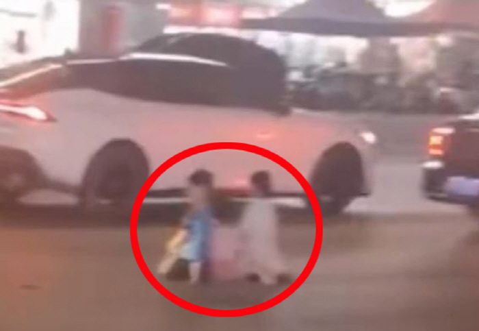 A man kneeling on the road with three children 'Anger''To bring his wife back'