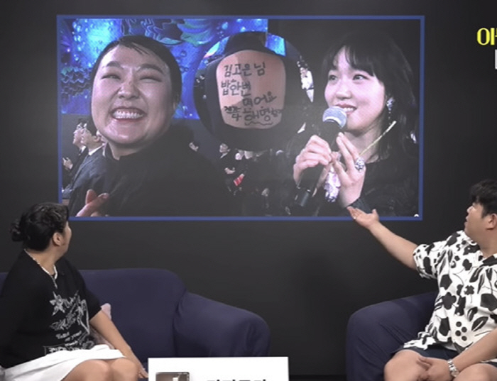 Lee Suji and Kim Goeun in front of the 'Flood' parody 'I'll explain everything.' ('Fathernus')