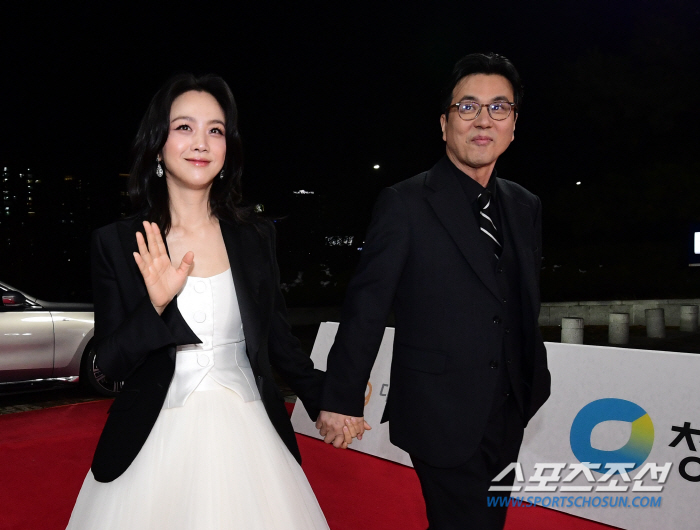  Director Tang Wei and Director Kim Taeyong, holding hands in a kind way