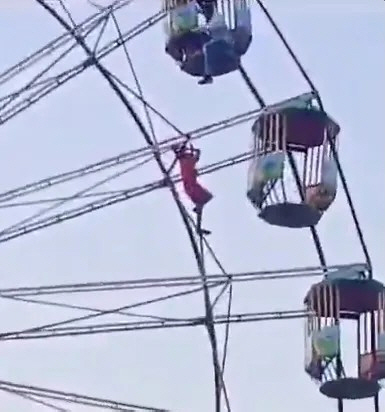 Teenage girl hanging from 20m high Ferris wheel, how?