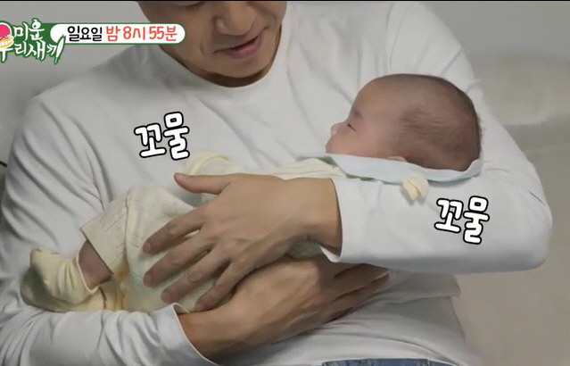 Kim Jong-min, the groom-to-be, smiles at his father in his baby's arms..I've never seen a happy face like this before